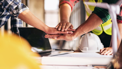 Three people are holding hands in a circle